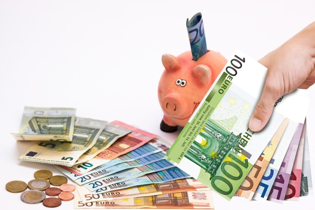 hucha-de-cerdito-con-un-billete-de-veinte-euros-metido-mano-sujetando-billetes-y-billetes-y-monedas-sueltos