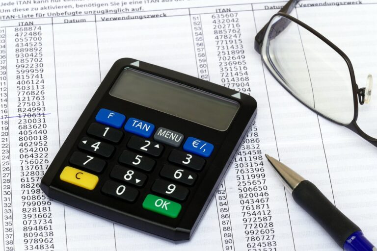 calculadora-papel-boli-y-gafas-de-una-persona-que-esta-comparando-seguros-de-vida