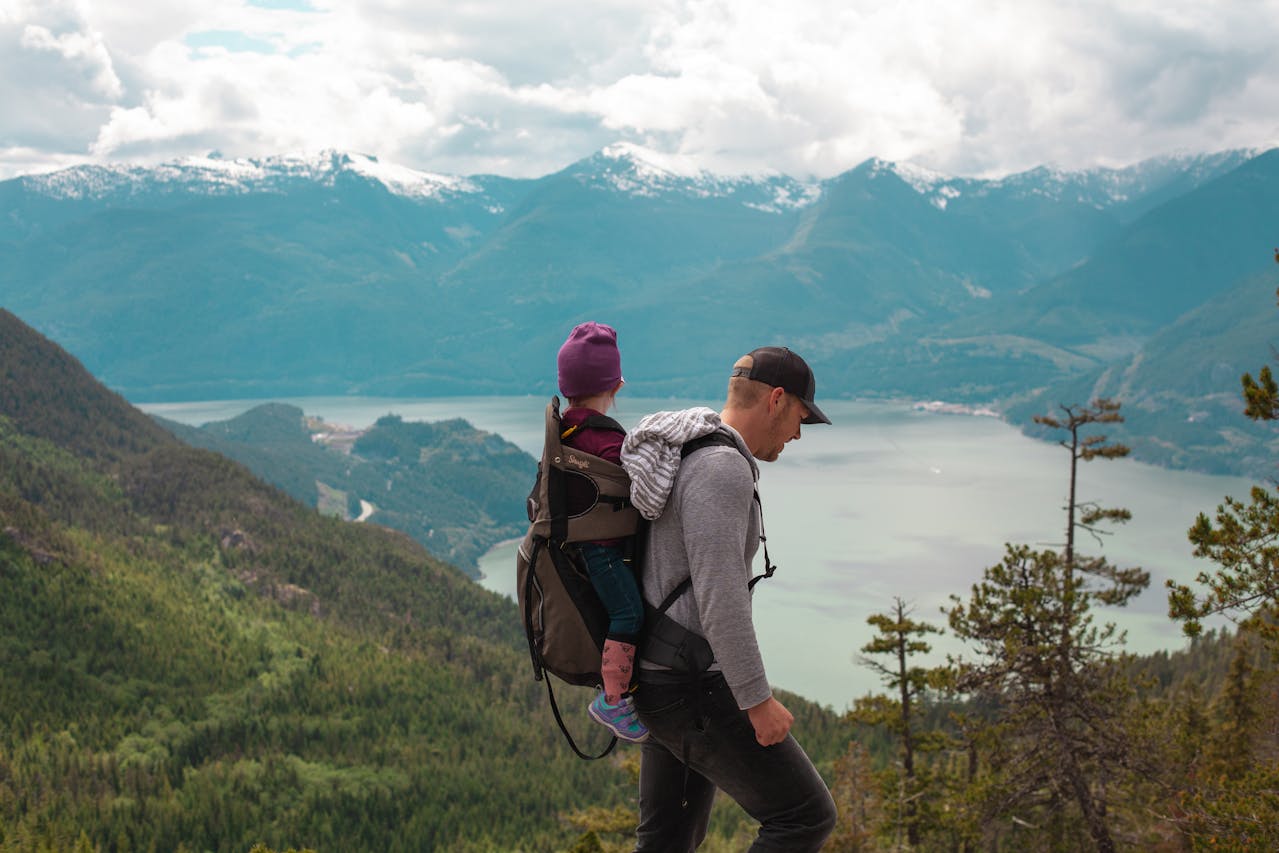 hombre-con-bebe-en-la-montaña-practicando-turismo-sostenible