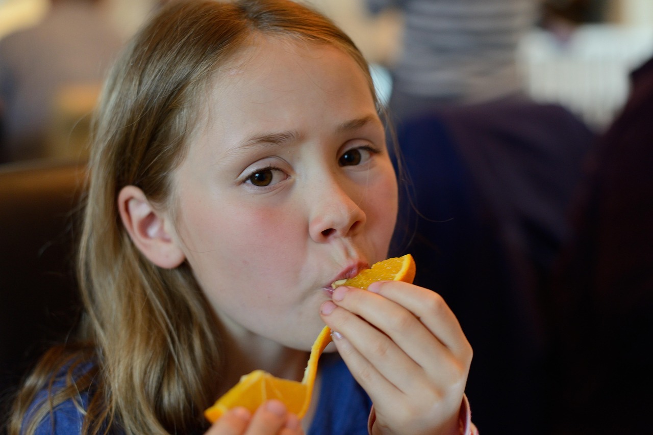 nina-comiendo-fruta-evita-obesidad-infantil