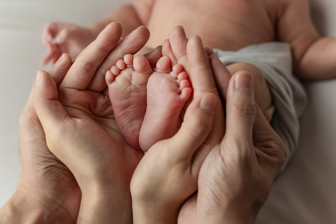 pies-recien-nacido-rodeado-de-las-manos-de-sus-padres